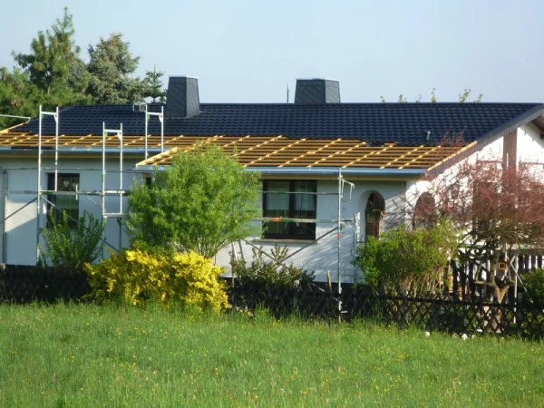 Ein Decra-Metalldach in Ziegeloptik eingedecktes Haus. Für die Sanierung direkt auf die defekte Bitumschindeldeckung mit Hinterlüftung verlegt.